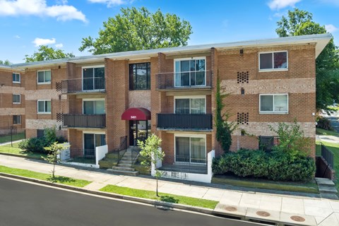 A red brick apartment building with a balcony on the second floor.